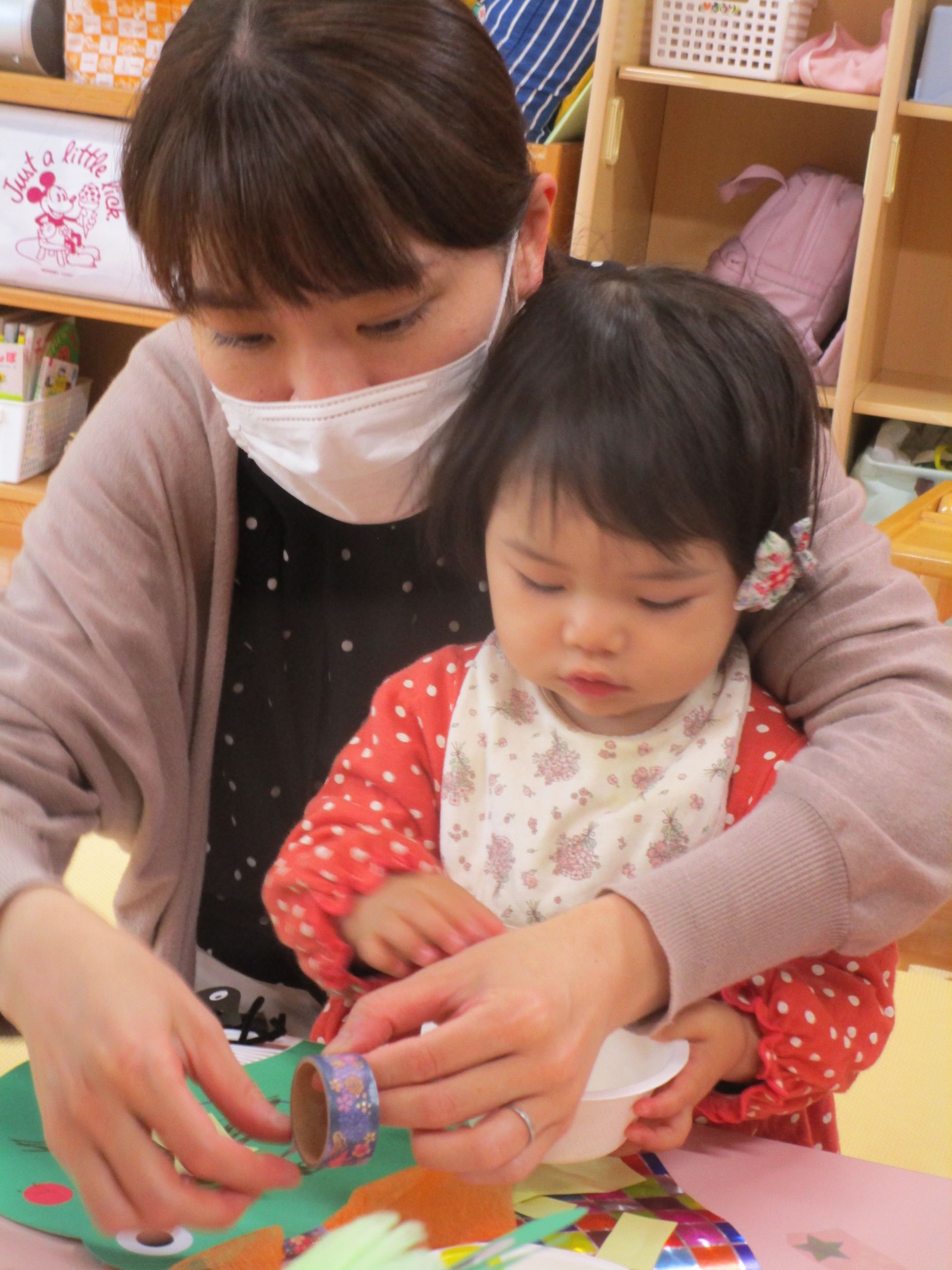 お母さんと一緒にシールを貼る女の子