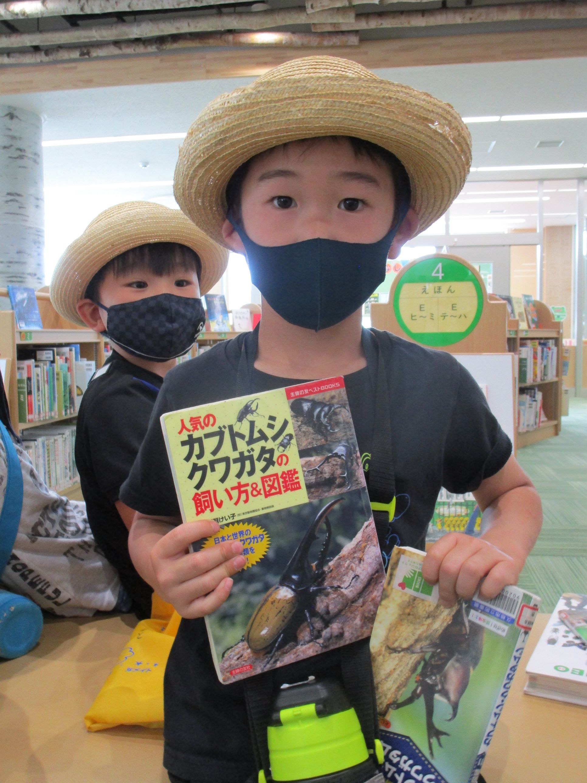 かぶと虫の本を持つ男の子