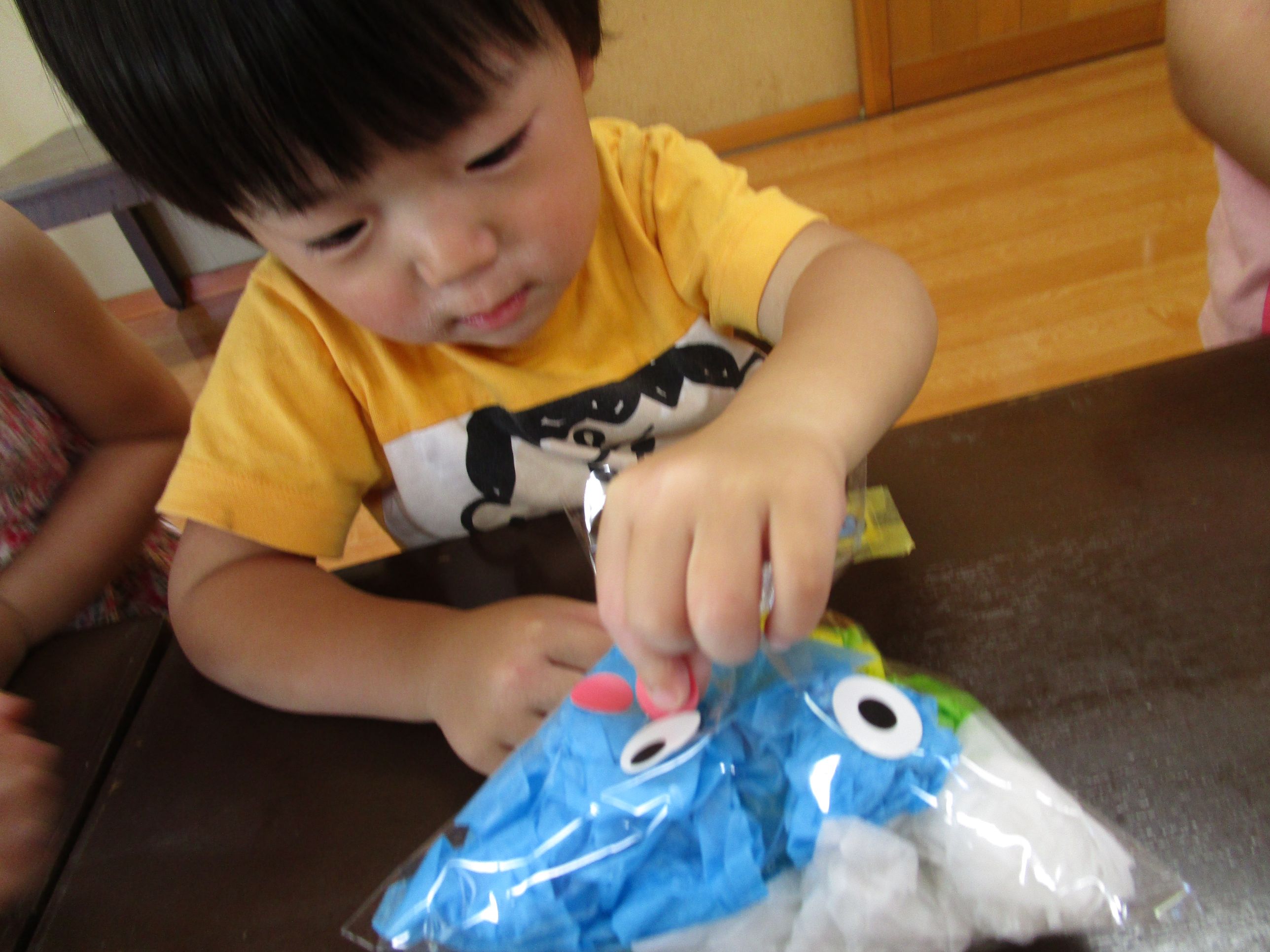 目のシールを貼る男の子